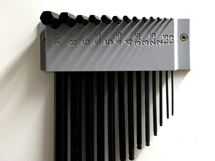 Soporte de pared gris impreso en 3D con llaves Allen métricas ordenadas por tamaño y medidas grabadas