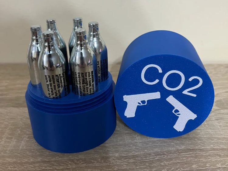 Soporte cilíndrico azul para cartuchos de CO₂ de 12 g con tapa, mostrado con cartuchos no incluidos.